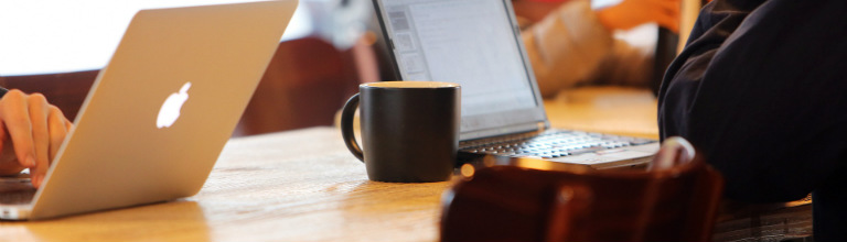 people in coffee shop writing on laptops