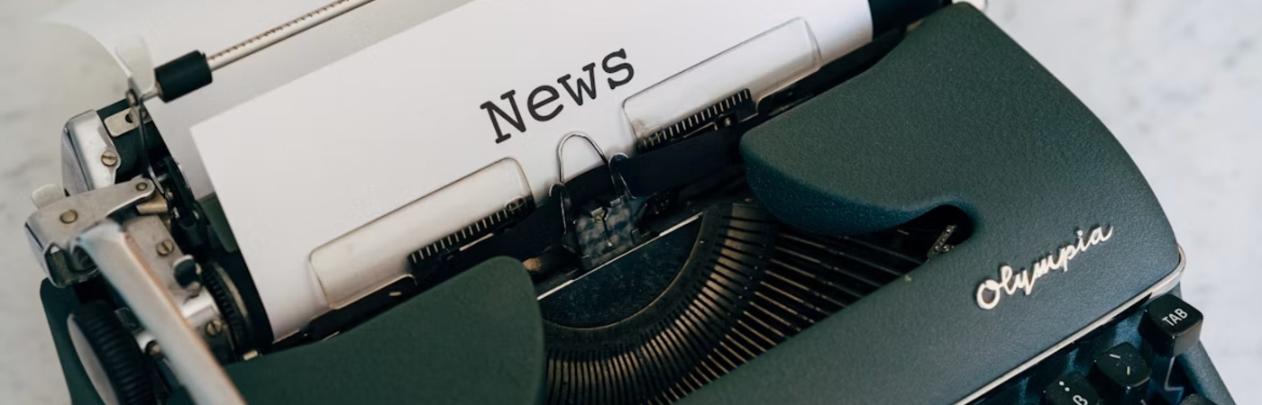 Green typewriter writing news.