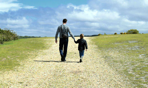 father and son walking across a field