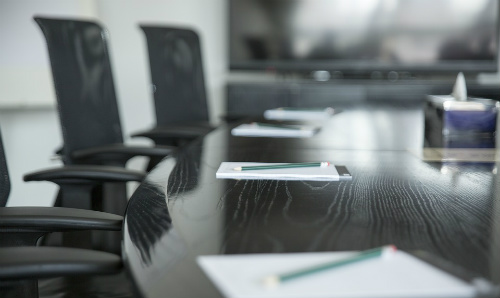 empty boardroom with pads and pencils on table