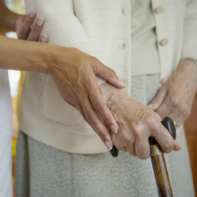 Close up of caregiver helping older woman walk