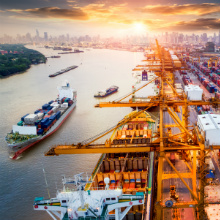 cargo ship with working crane bridge in shipyard