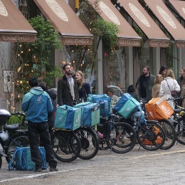 A group of delivery drivers waiting outside a restaurant.