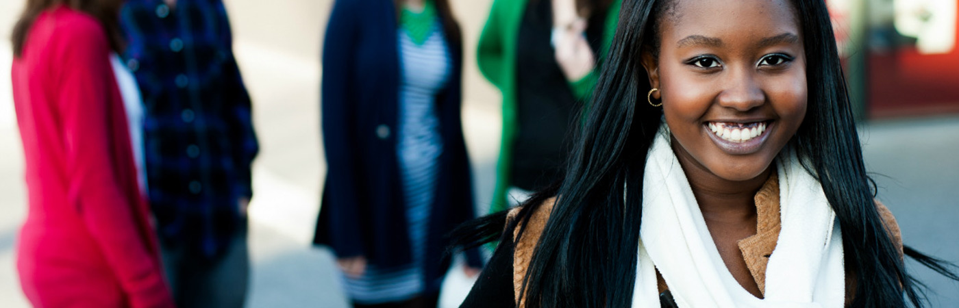 smiling student with blurred figures in background