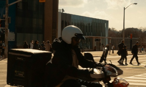 A man riding a motorbike in a city.