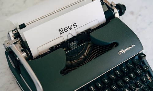 Green typewriter writing news.